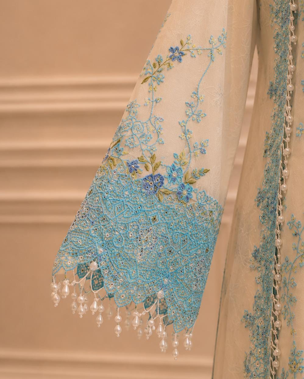 Sky blue embroidery detail on sleeve of ivory formal suit